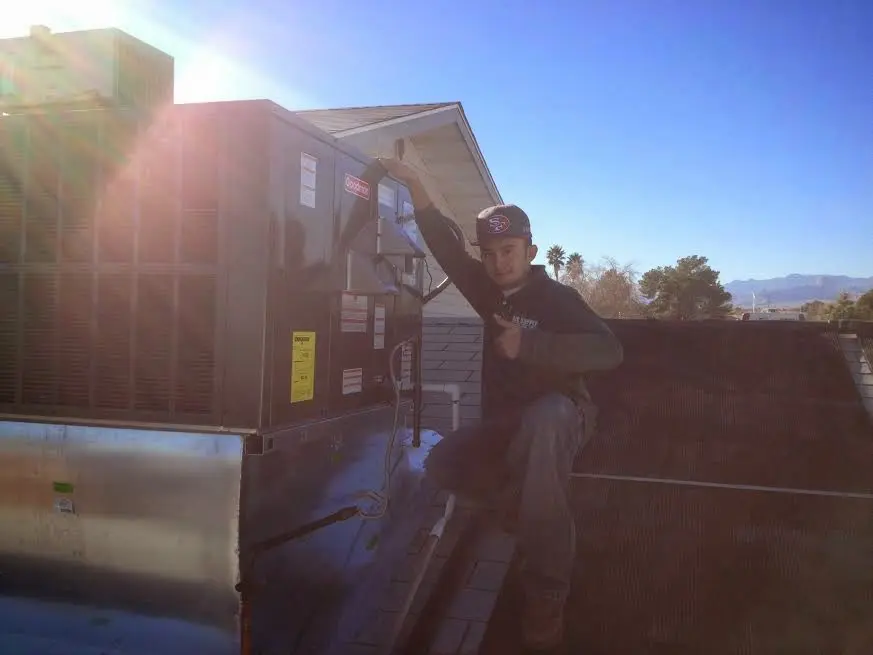 HVAC technician performing HVAC Inspection on a rooftop unit in Oswego